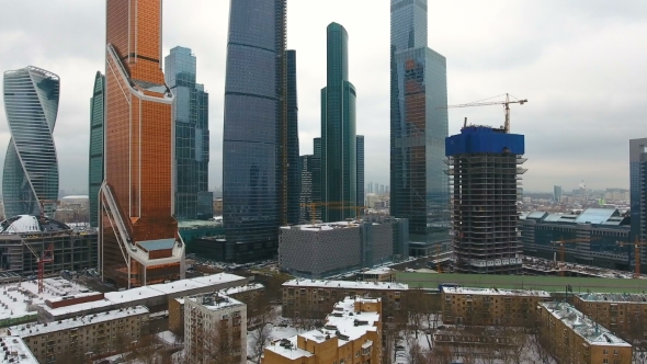 Contrast of Poverty with Wealth. Old Houses with Skyscraper on Background. alt