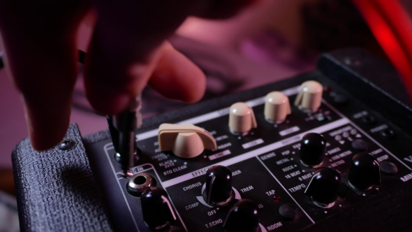 Man's Hand Removes the Cable Jack From Guitar Amp