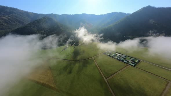 Shooting From Helicopter Natural Mist Over Meadow Countryside Agricultural Village Mountain
