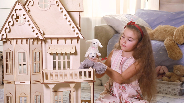 Little Girl Playing With a Doll-House alt