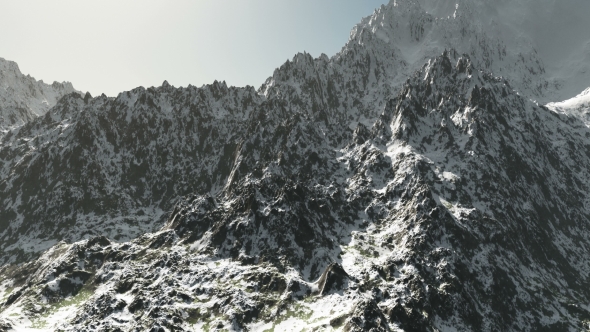 Mountains in Snow and Clouds at Blue Sky