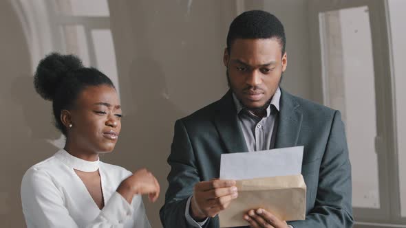 Concentrated 25's African American Young Man Holding Paper Document Feeling Unhappy with Negative