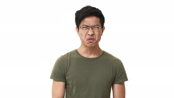 Portrait of Displeased Asian Man 20s Wearing Glasses Frowning While Expressing Disgust and Aversion