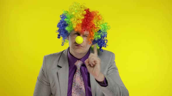 Clown Businessman Entrepreneur Boss in Wig Quarrels and Waves His Finger at Work