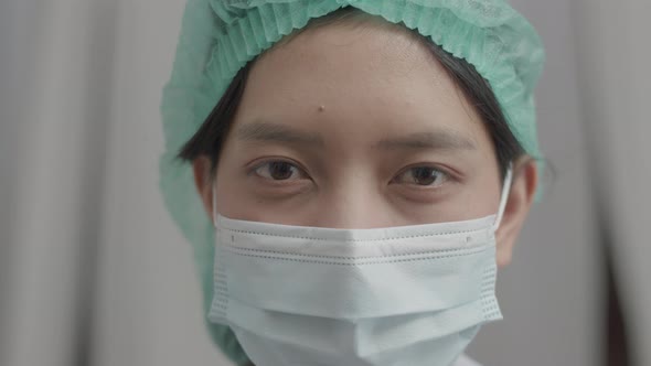 Close Up Asian nurse with face mask in medical protective uniform working in the hospital.