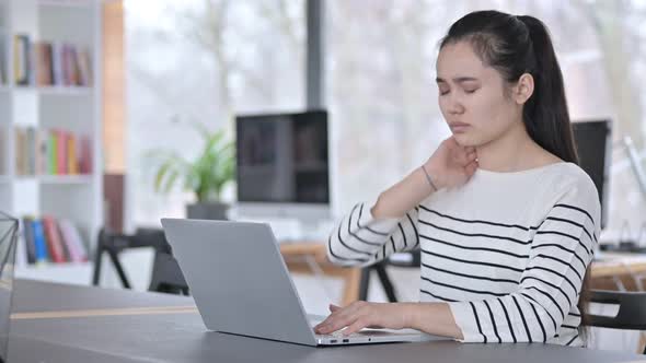 Laptop Use By Young Asian Woman with Neck Pain in Office 
