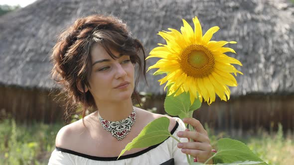 Woman smelling a sunflower alt