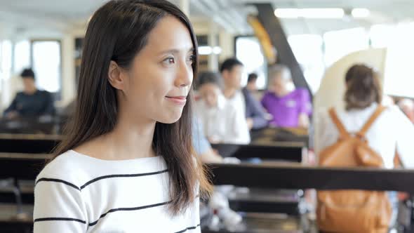 Woman taking photo with cellphone on star ferry in Hong Kong