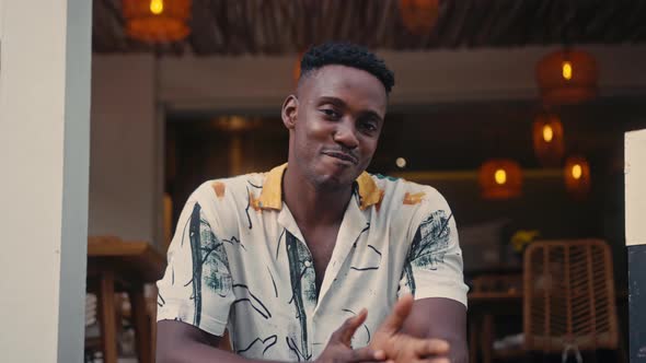 AfricanAmerican Man Smiles While Standing in a Coffee Shop