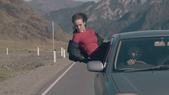 Wind Plays with Hair of Relaxed Brunette Driving in Car