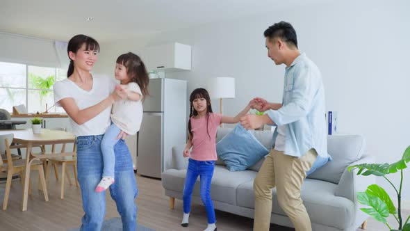 Asian happy family listen to music and dancing together with young kids in living room in house.