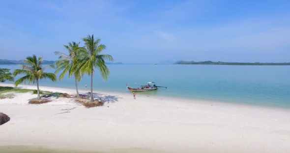 Aerial: The Girl Plays with a Ball on the White Sandy Beach Near the Boat