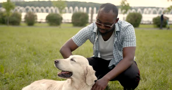 Black Man Stroking His Dog in the Park