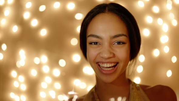 Young Beautiful Female Portrait with Holiday Lights on the Background