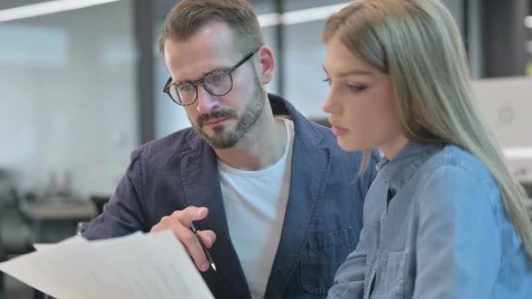 Woman Explain Documents to Male Colleague