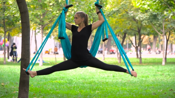 Girl in a Park Engaged in Aerial Yoga