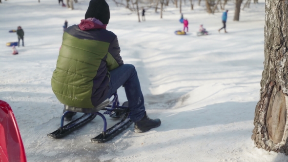 Happy Children Ride From a Hill. Concept Winter Family Holiday, Healthy Lifestyle, Cheerful Mood