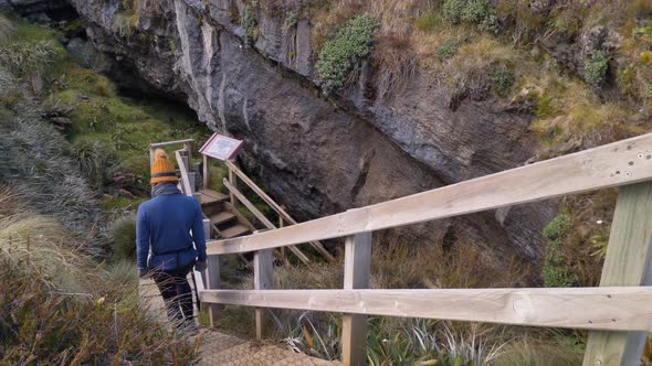Slider, person descends stairs to Luxmore Cave, Kepler Track side trip, New Zealand