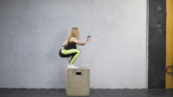 Woman Jumping Up on Box in Cross Fit Gym