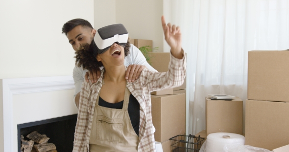 Happy Young Couple Doing Virtual Tour in New Apartment