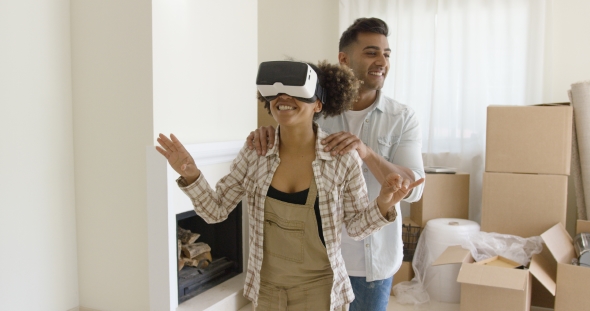 Happy Young Couple Doing Virtual Tour in New Apartment