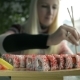 Girl Eating Sushi with Chopsticks in a Japanese Restaurant Focus on the Sushi - VideoHive Item for Sale