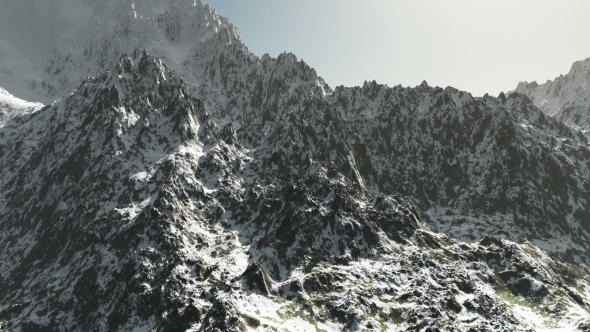 Mountains in Snow and Clouds at Blue Sky