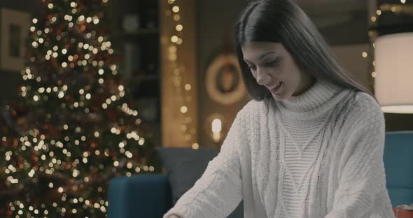 Young woman preparing gifts for Christmas.