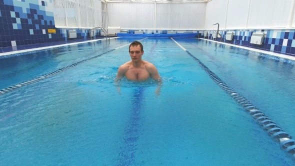 Young Man Swimming the Breaststroke in a Pool