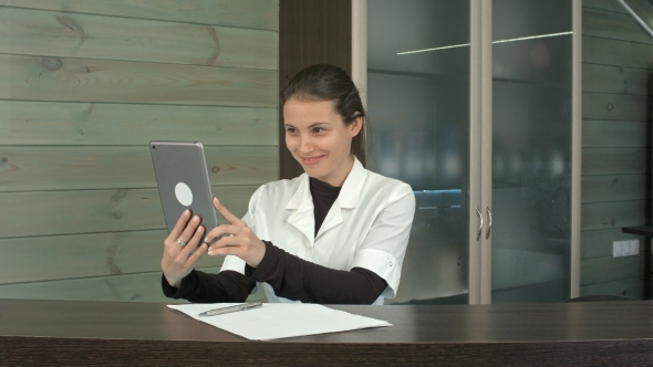 Happy Spa Manager Taking Selfies with Her Tablet at the Reception Desk