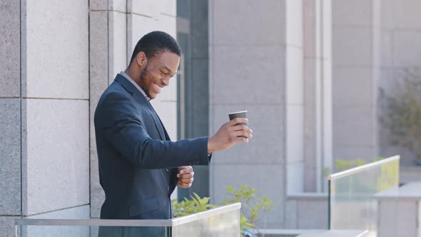 Smiling Young Confident African American Businessman Standing on Balcony of Office Enjoying Rest