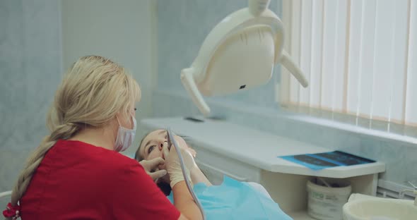 Young Girl Treats a Tooth at the Dentist