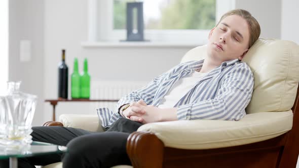 Portrait of Drunken Relaxed Man Sleeping on Armchair at Home