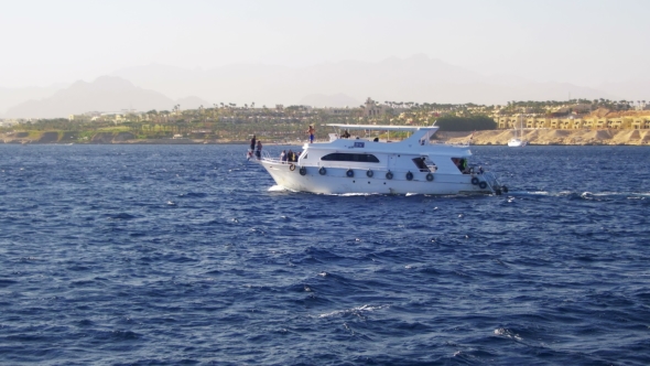 Pleasure Boat Floats on the Waves of the Red Sea on the Background of Coast and Beaches in Egypt