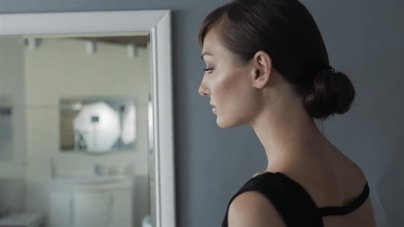 Pretty Girl Making Makeup in Bathroom Look on Mirror