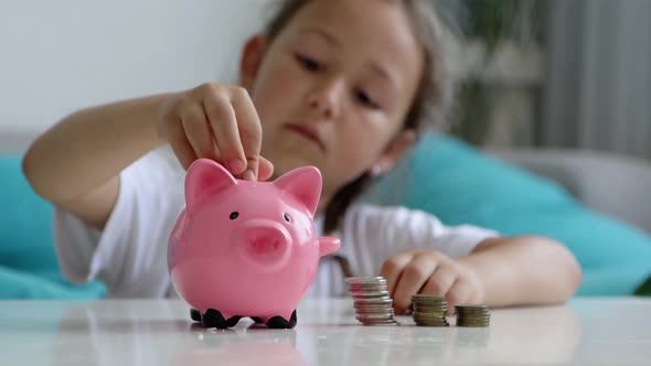 Little Girl Saves Money with a Piggy Bank at Home