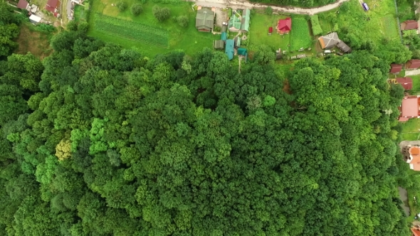 View From a Great Height on a Small Village in the Valley Among the Hills of the Forested Mountains