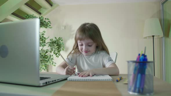 Homework With Laptop Computer.Focused Little Cute Kid Studying at Table doing homework