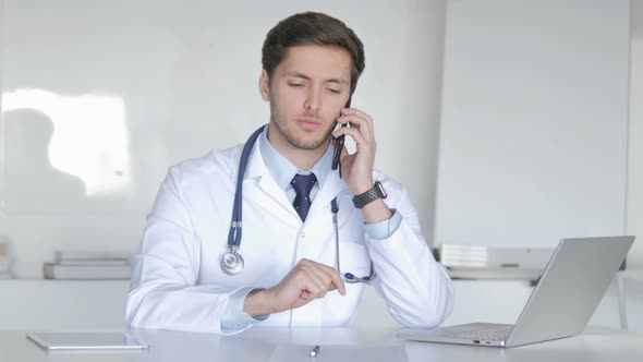 Young Doctor Talking with Patient on Phone