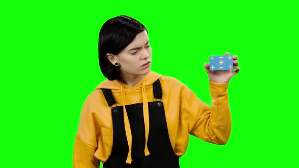 Girl Card in Her Hand and Shows Her Finger Down. Green Screen