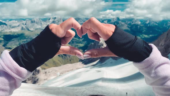 Woman Creating Heart Sign with Her Hands on a Mountain Scenario