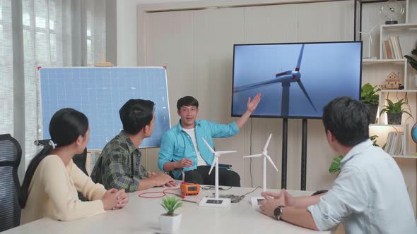 Asian Man Engineer In Wheelchair Presenting About The Wind Turbine At The Office