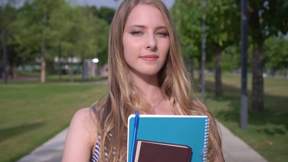 Student Girl with Notebook and Book in the Park. Woman Student Outdoors