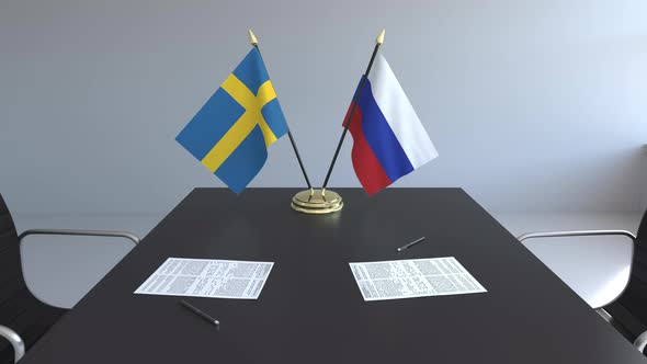 Flags of Sweden and Russia and Papers on the Table