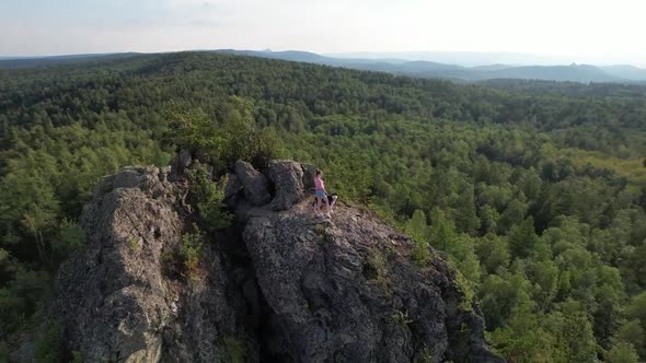 Girl Stands on a Rock with a Dog Shooting From a Drone