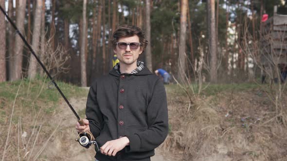 A guy is fishing with spinning in a forest area