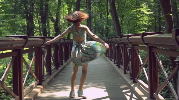 A Pretty Young Girl Is Spinning in the Park in .