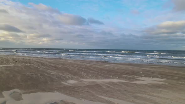 Aerial view of rolling waves and sunrise at the ocean close to Løkken by the North Sea, Denmark