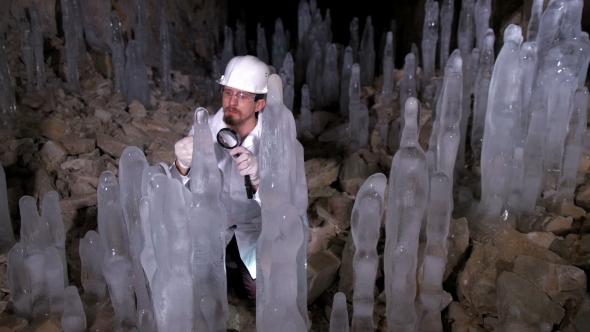 A Scientist Studying Ice Stalagmites in the Cave alt