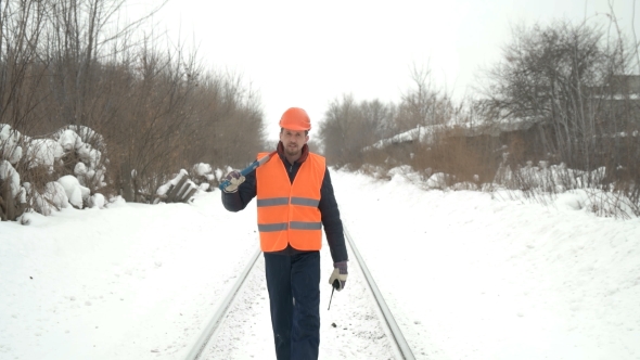 Worker with a Sledgehammer Goes Along the Railway